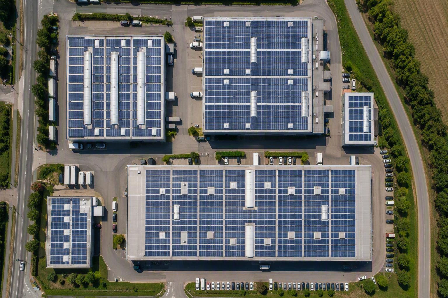Gewerbegebäude Gewerbepark mit Dächern, die mit Solarpaneelen gedeckt sind. Optik Drohne Draufsicht
